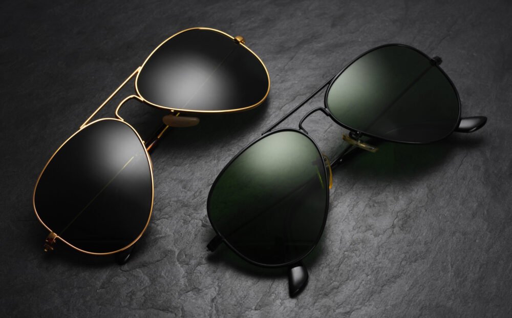 Classic old fashion aviator sunglasses on black slate background. Top view