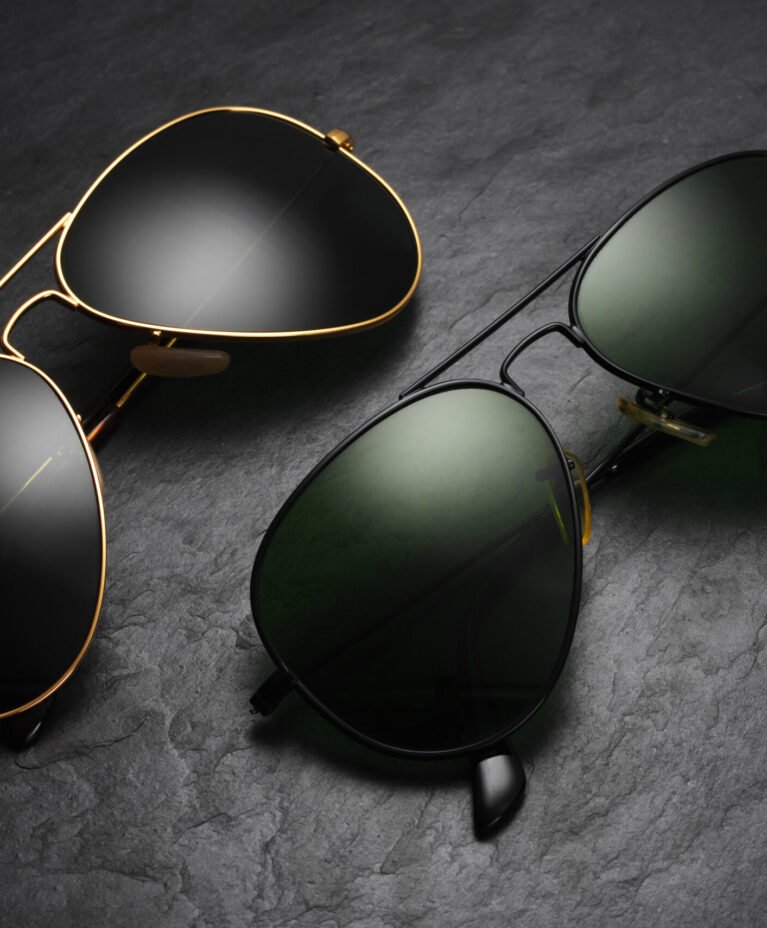 Classic old fashion aviator sunglasses on black slate background. Top view
